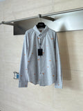 Light blue long-sleeve button-up shirt with orange dog embroidery, on a hanger
