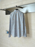 Light blue long-sleeve button-up shirt with orange dog embroidery, back view on hanger
