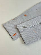 Light blue striped shirt cuffs with orange dog embroidery and two-button detail