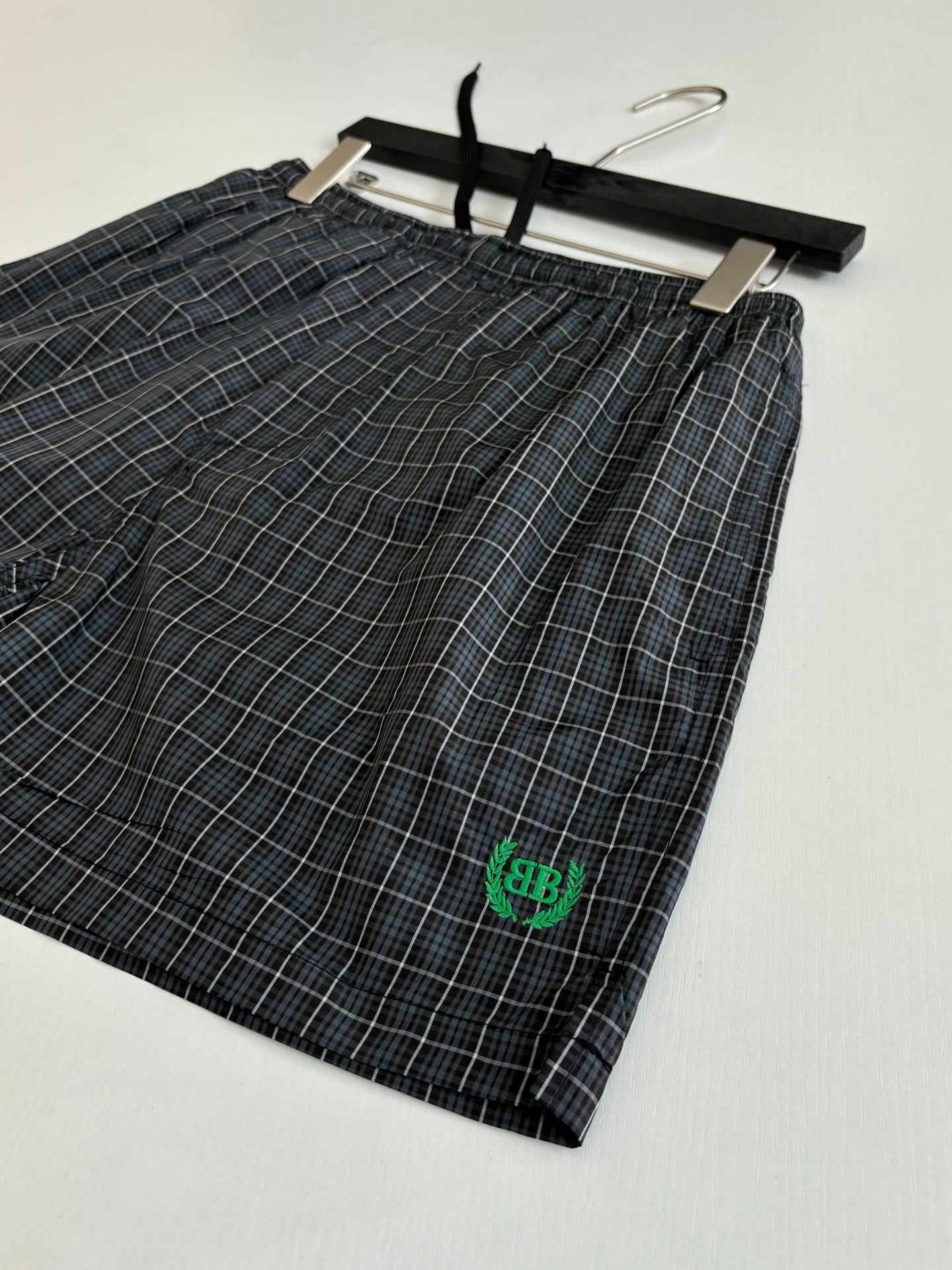 Balenciaga plaid shorts with elastic waist, black tie and green logo patch