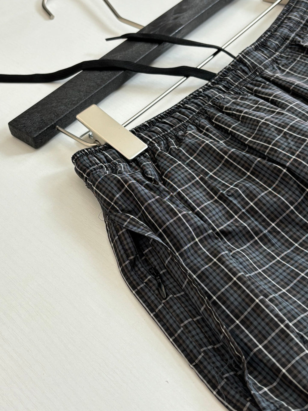 Balenciaga plaid shorts laid flat, showing elastic waist and drawstring