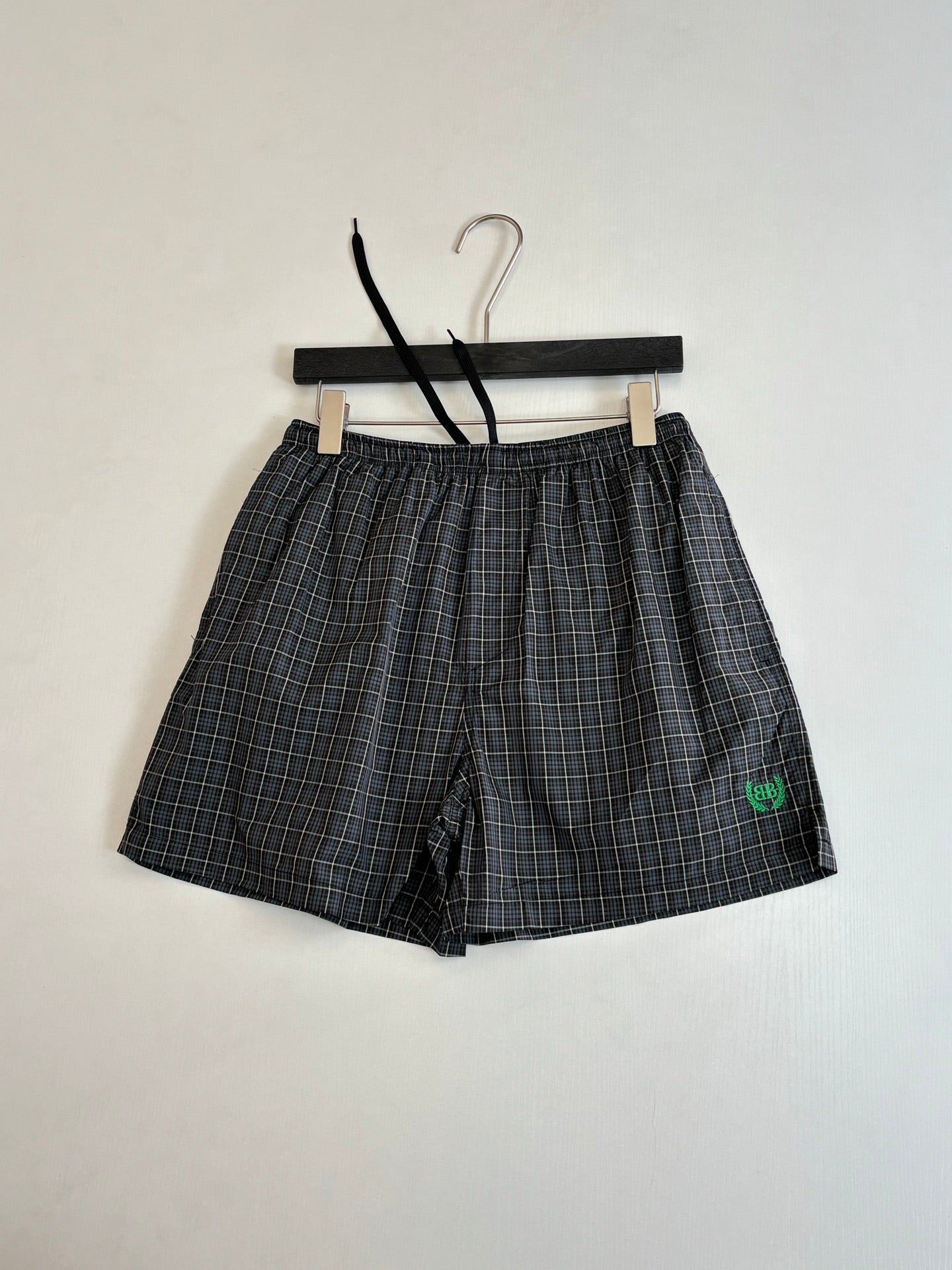 Balenciaga plaid shorts with front seams and green logo patch