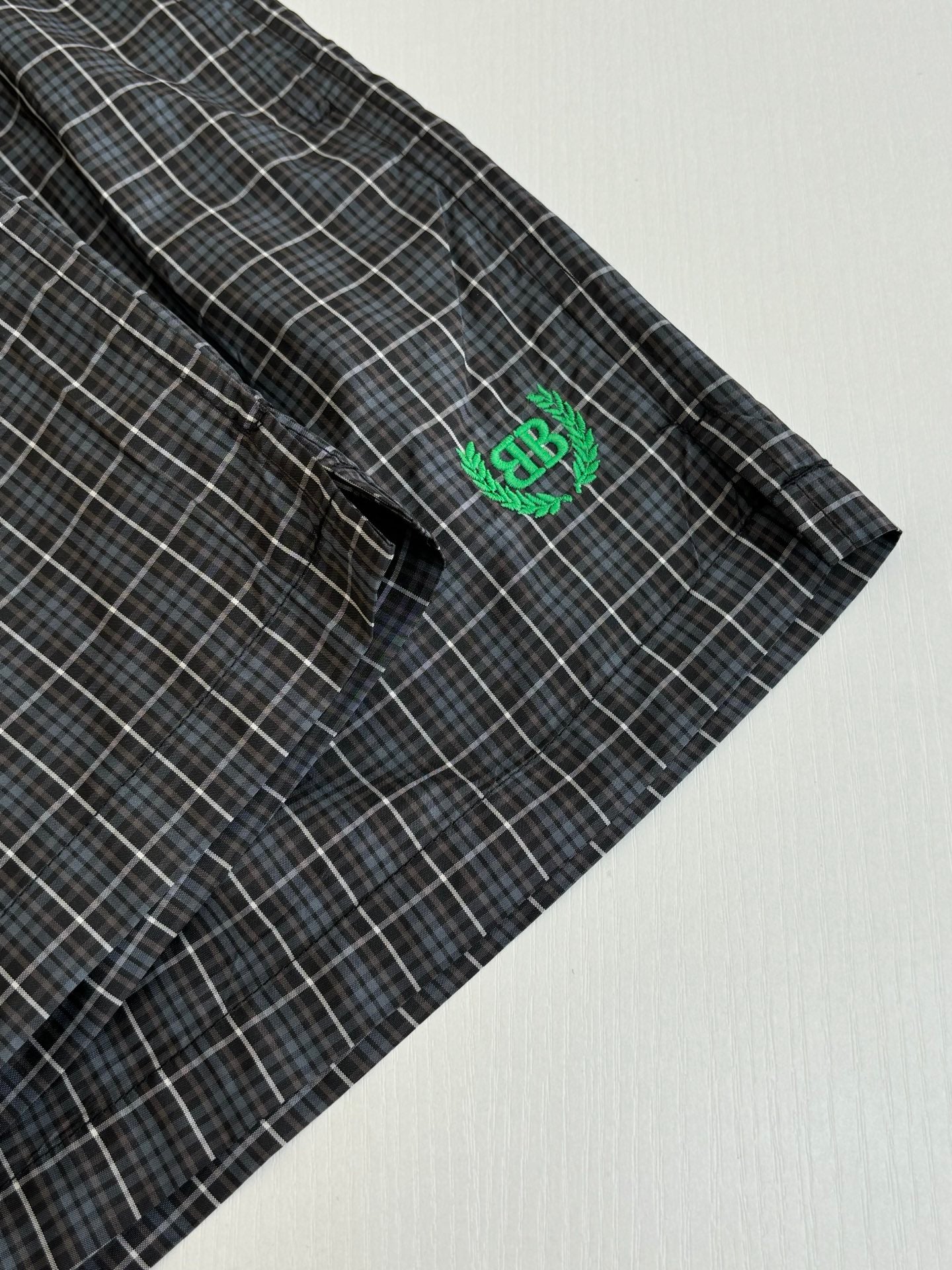 Balenciaga plaid shorts with green BR logo patch near side seam