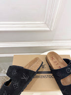 Monogram sandals with black straps and silver buckles, tan cork footbeds close-up