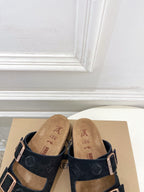 Monogram sandals with black straps and silver buckles, tan cork footbeds