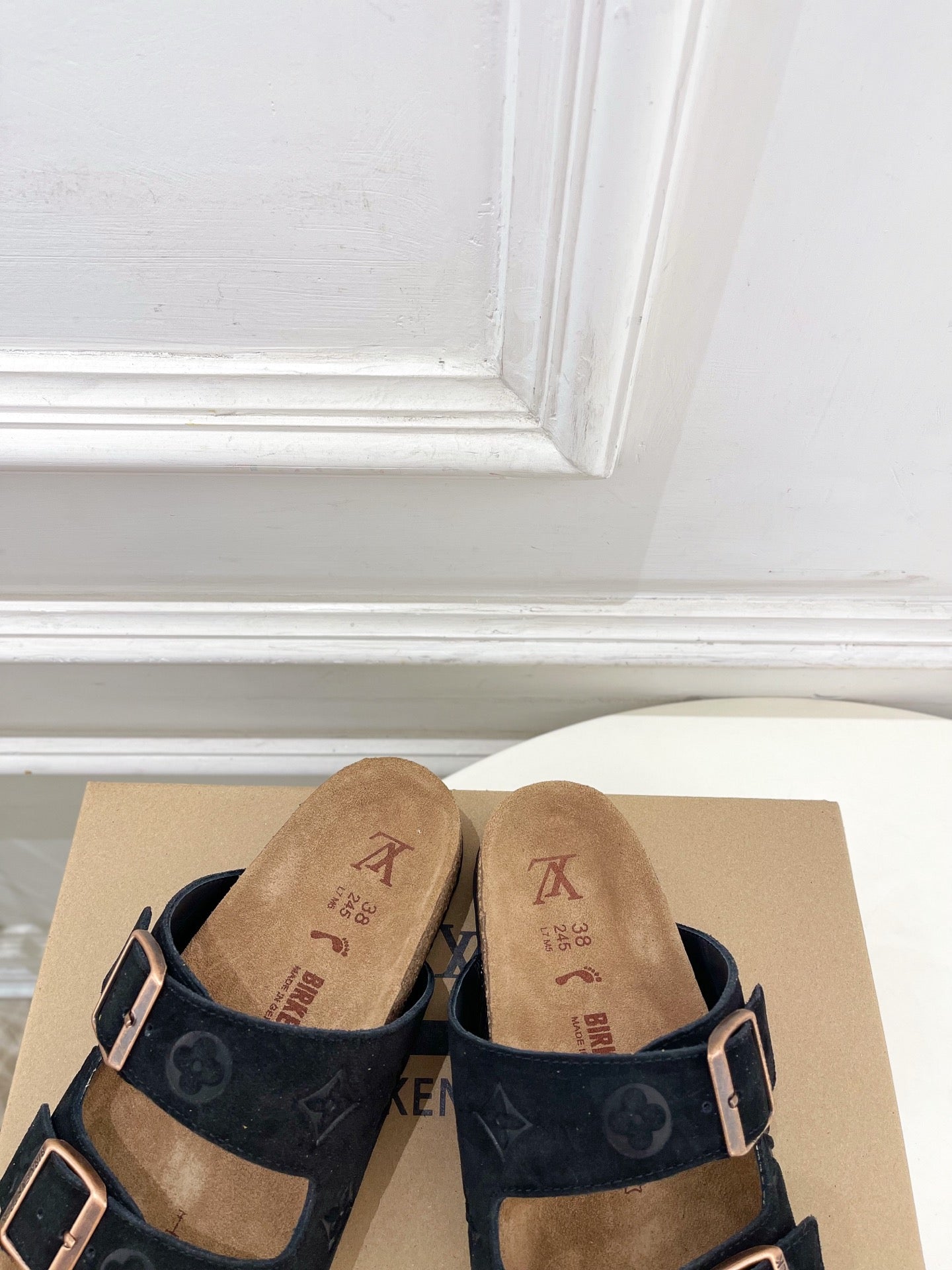 Monogram sandals with black straps and silver buckles, tan cork footbeds