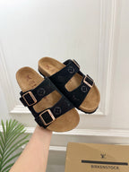 Monogram sandals with black straps and silver buckles, tan cork footbeds pair