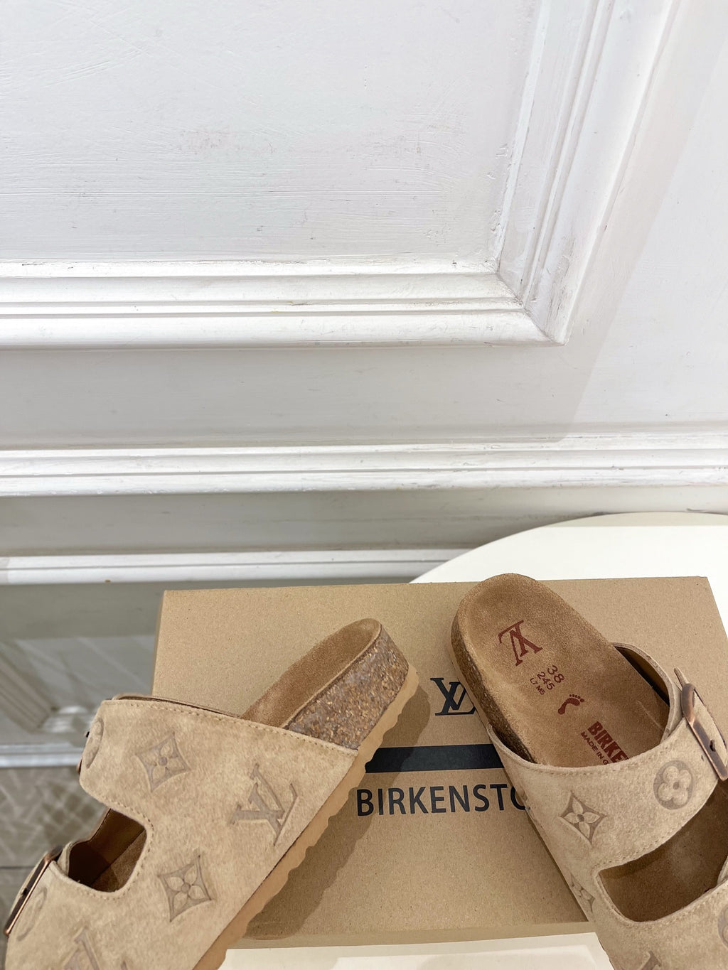 Louis Vuitton slide sandals showing tan footbed and monogram straps with buckles