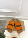 Orange Louis Vuitton sandals with two buckled straps and brown footbed.