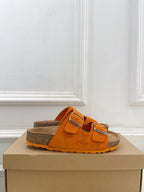 Orange Louis Vuitton slide sandals with two adjustable buckled straps and brown footbed.