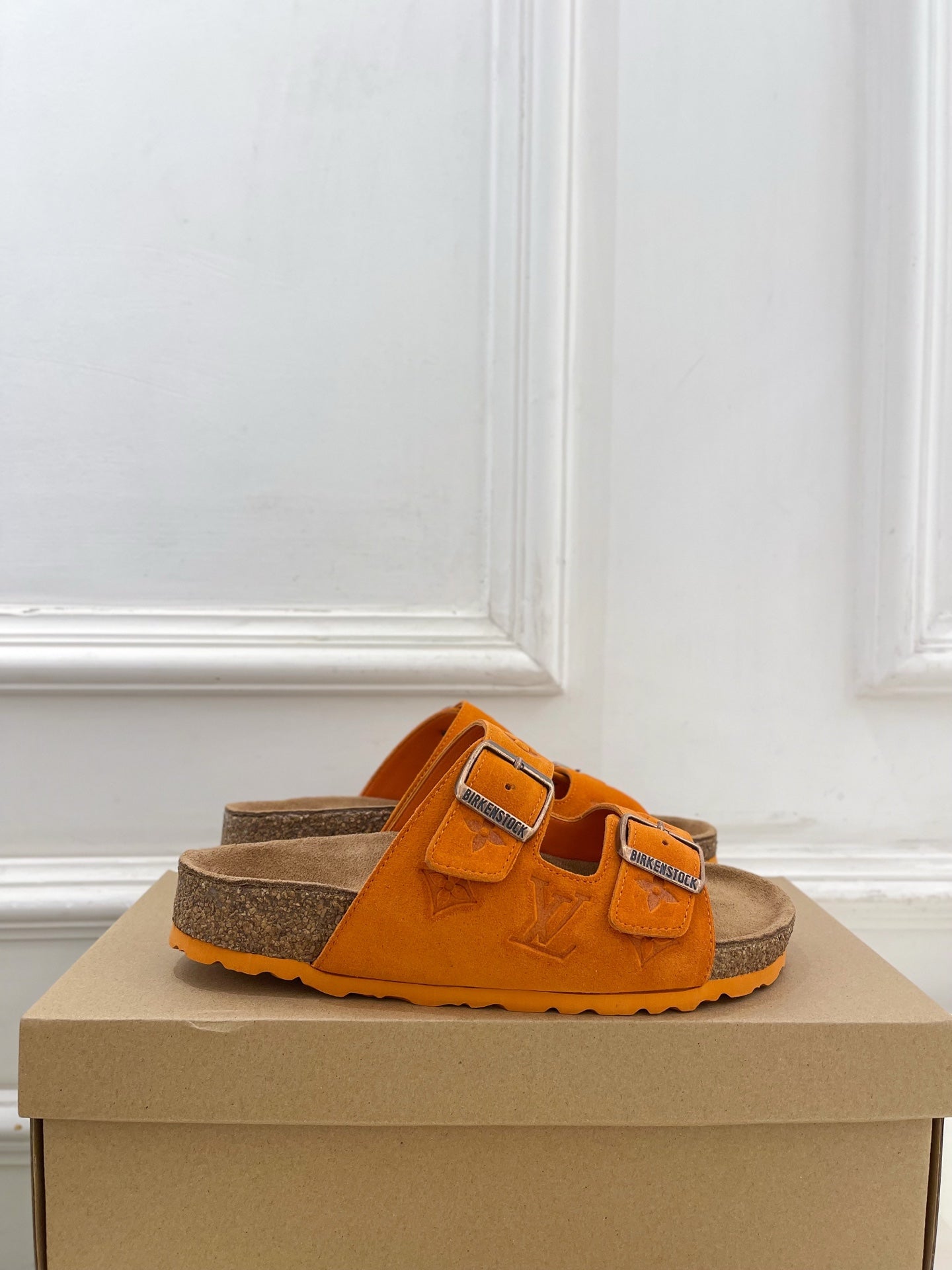 Orange Louis Vuitton slide sandals with two adjustable buckled straps and brown footbed.
