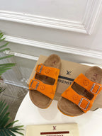 Orange Louis Vuitton sandals with two buckled straps and brown footbed, front view.