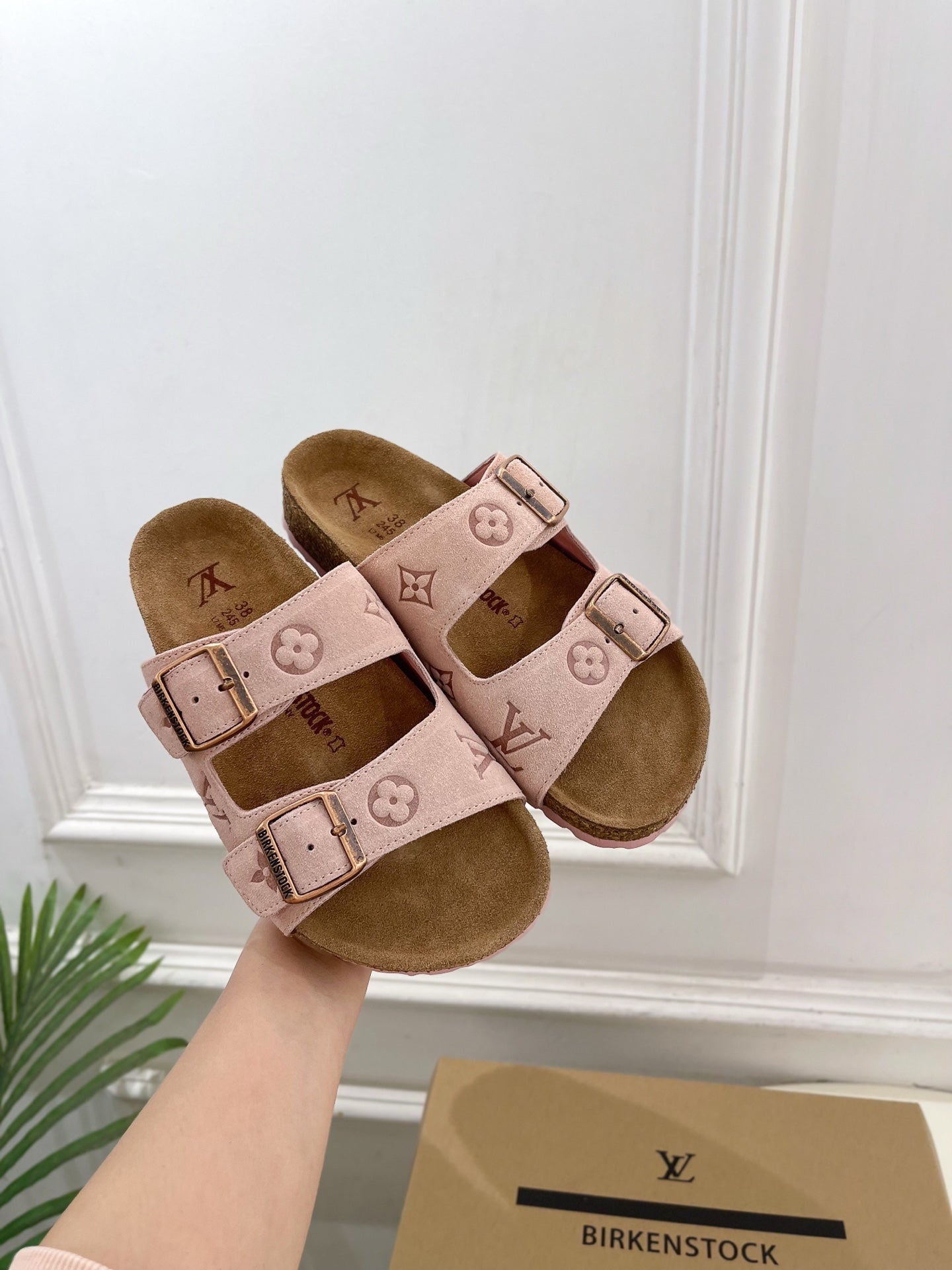 Louis Vuitton sandals with pale pink straps, monogram graphics, and adjustable metal buckles