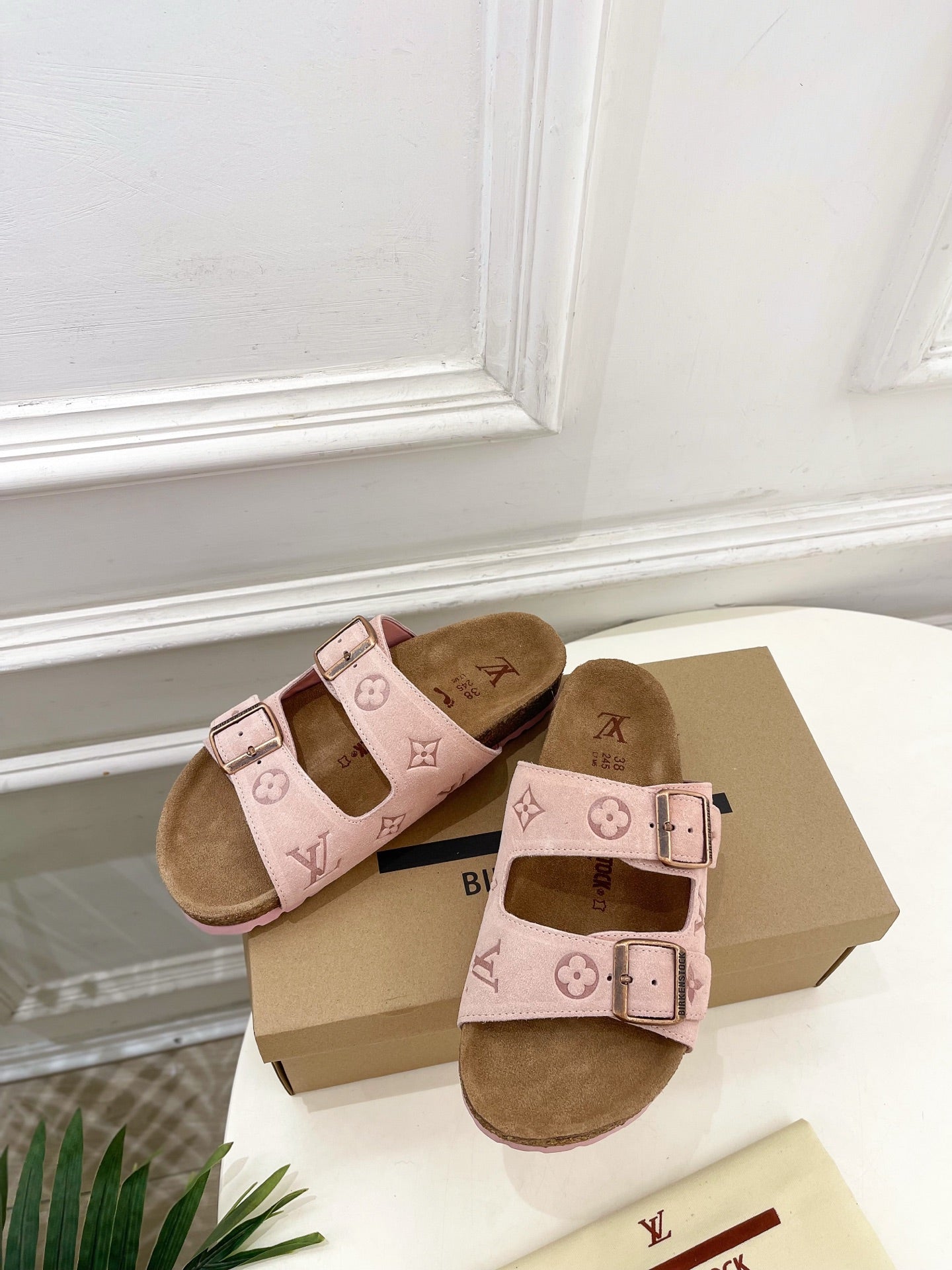 Louis Vuitton sandals pair with pale pink footbed straps, monogram motifs, and metal buckles