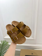 Pair of tan monogram sandals with two straps, silver buckles, and soft footbed