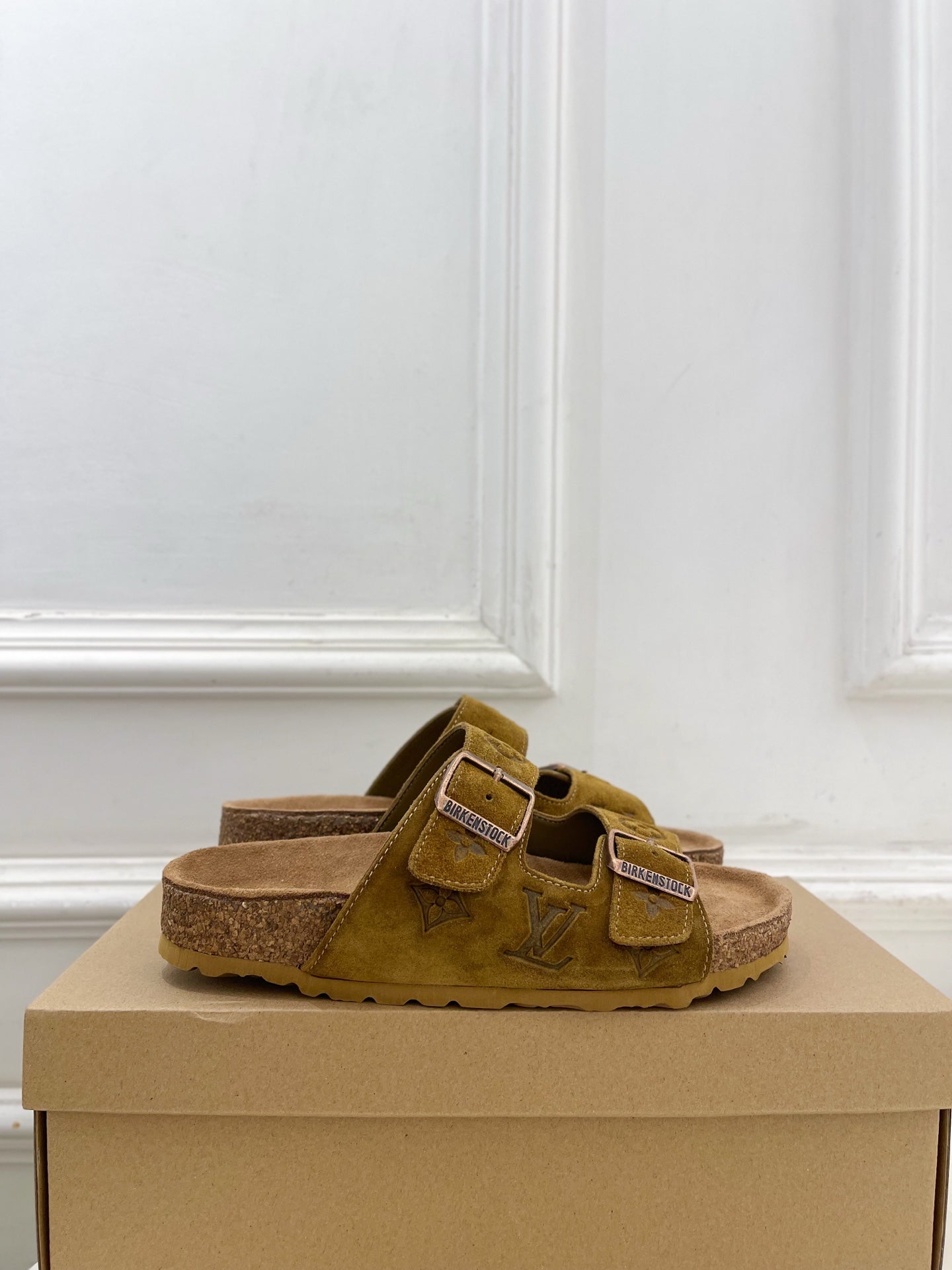 Brown suede-style slide sandals with two adjustable straps and silver buckles