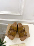 Tan monogram slide sandals with two buckled straps and cushioned footbed