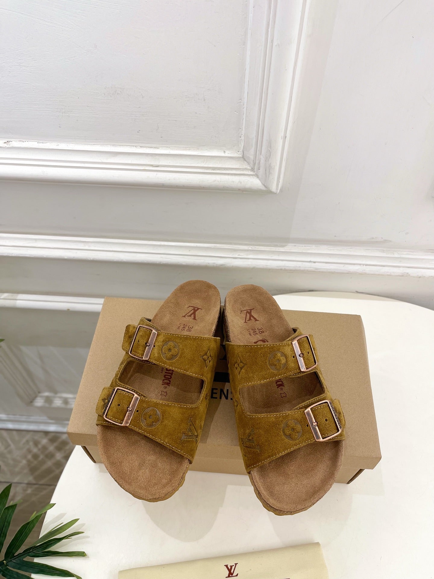 Tan monogram slide sandals with two buckled straps and cushioned footbed