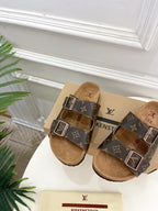 Brown monogram slide sandals with twin buckles and tan suede footbed