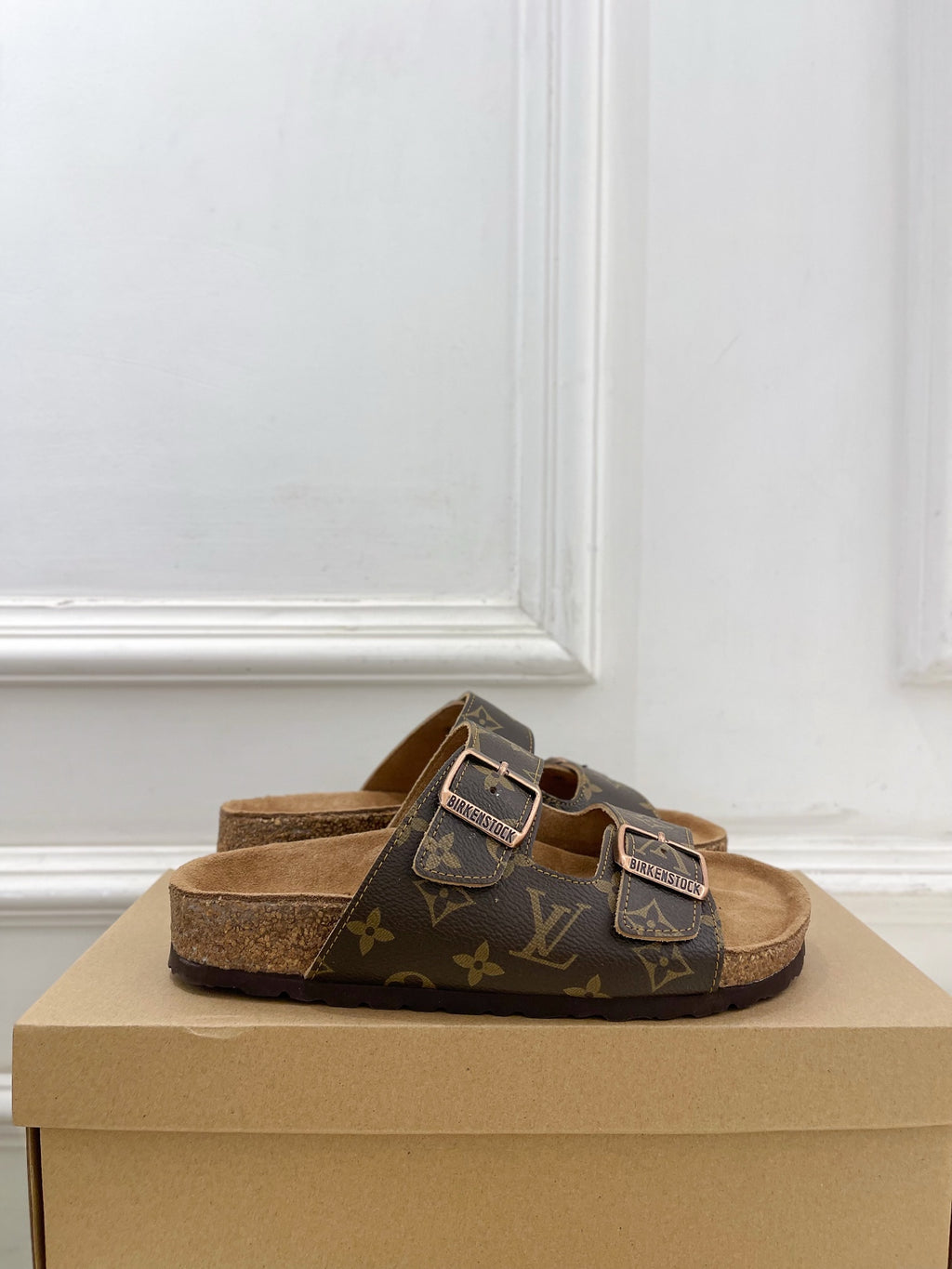 Dark monogram slide sandals with silver buckles and tan lining