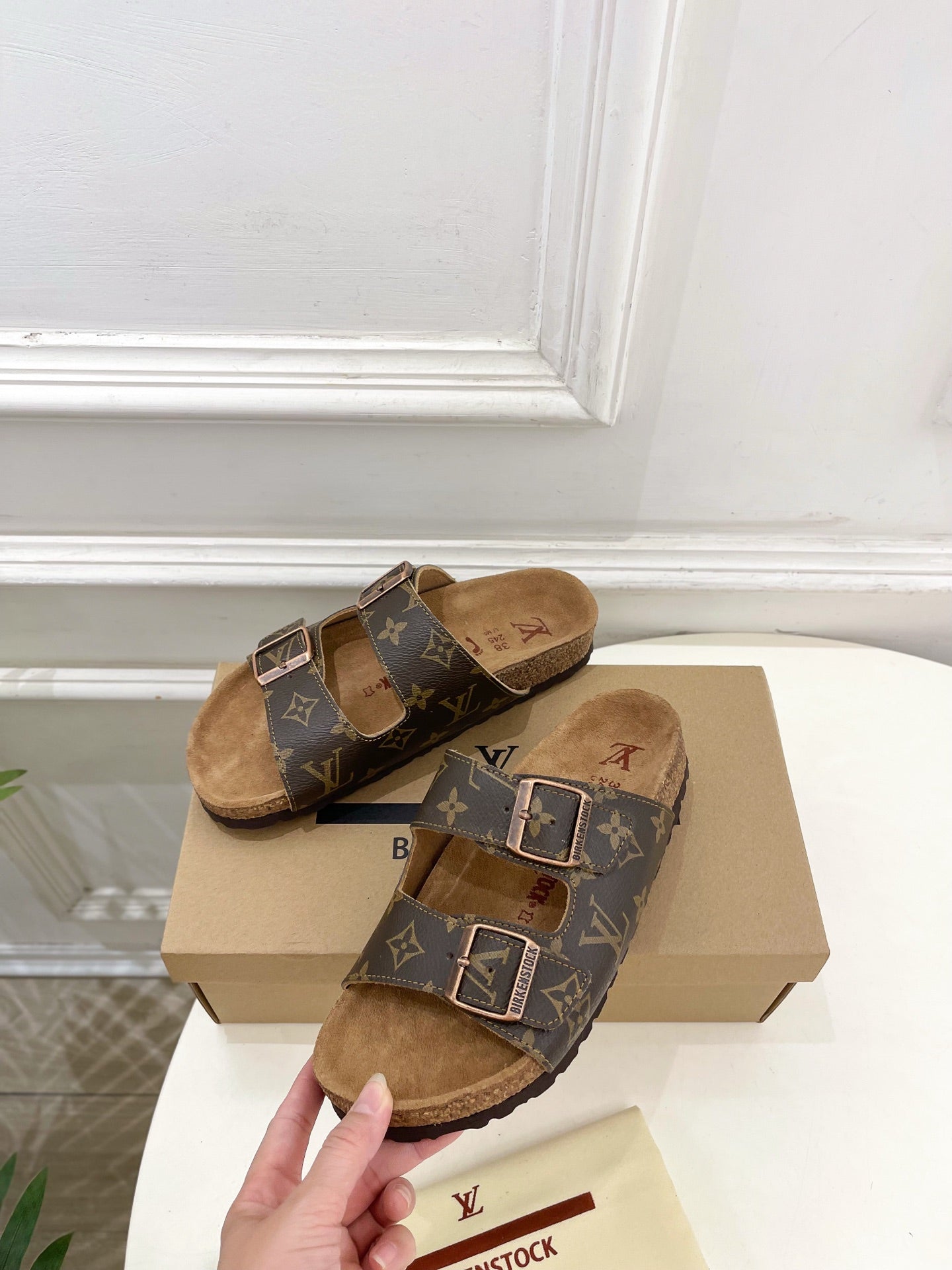 Brown monogram slide sandals with two silver buckles and tan suede lining