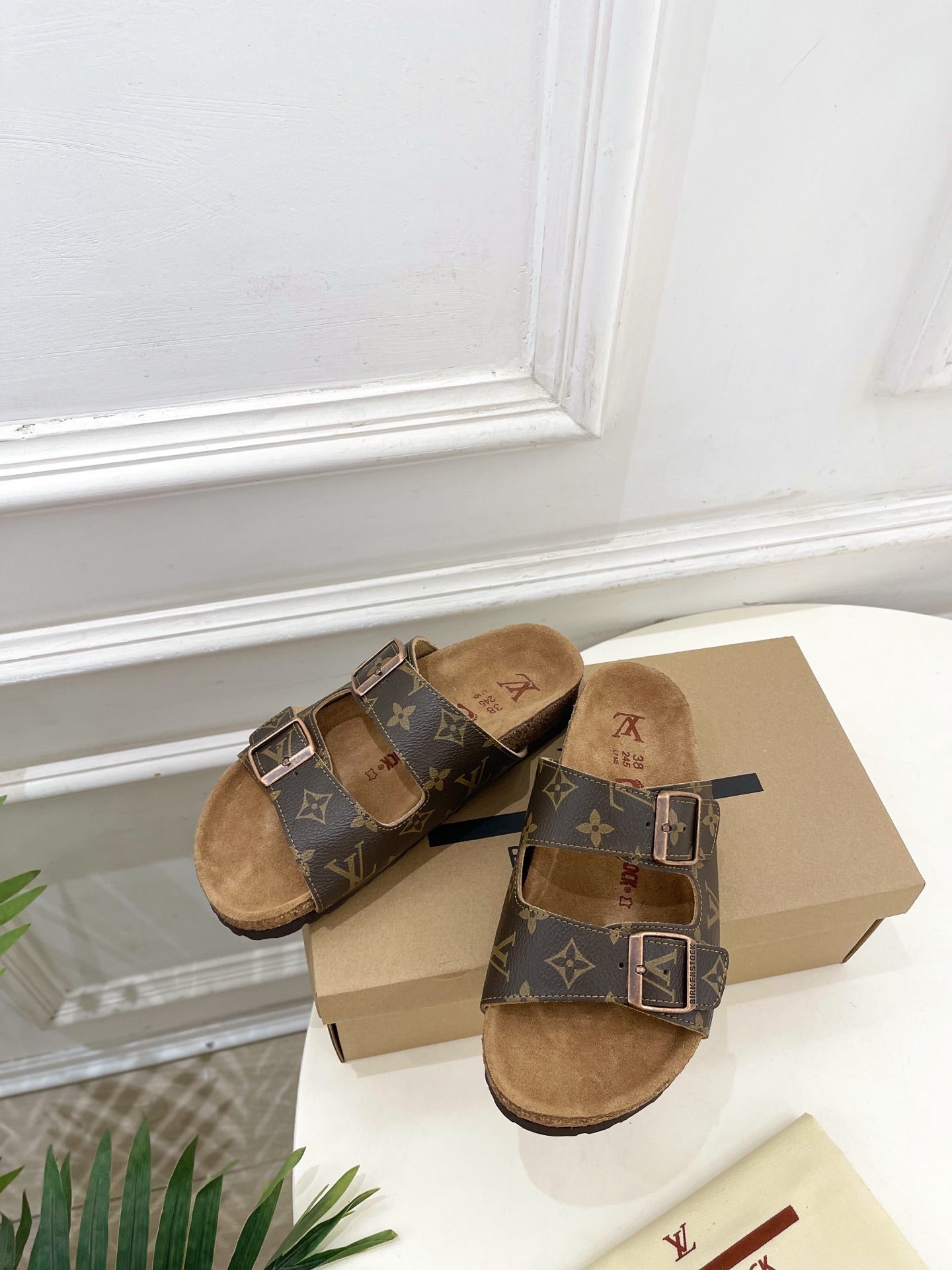 Brown monogram slide sandals with silver buckle straps and tan footbed