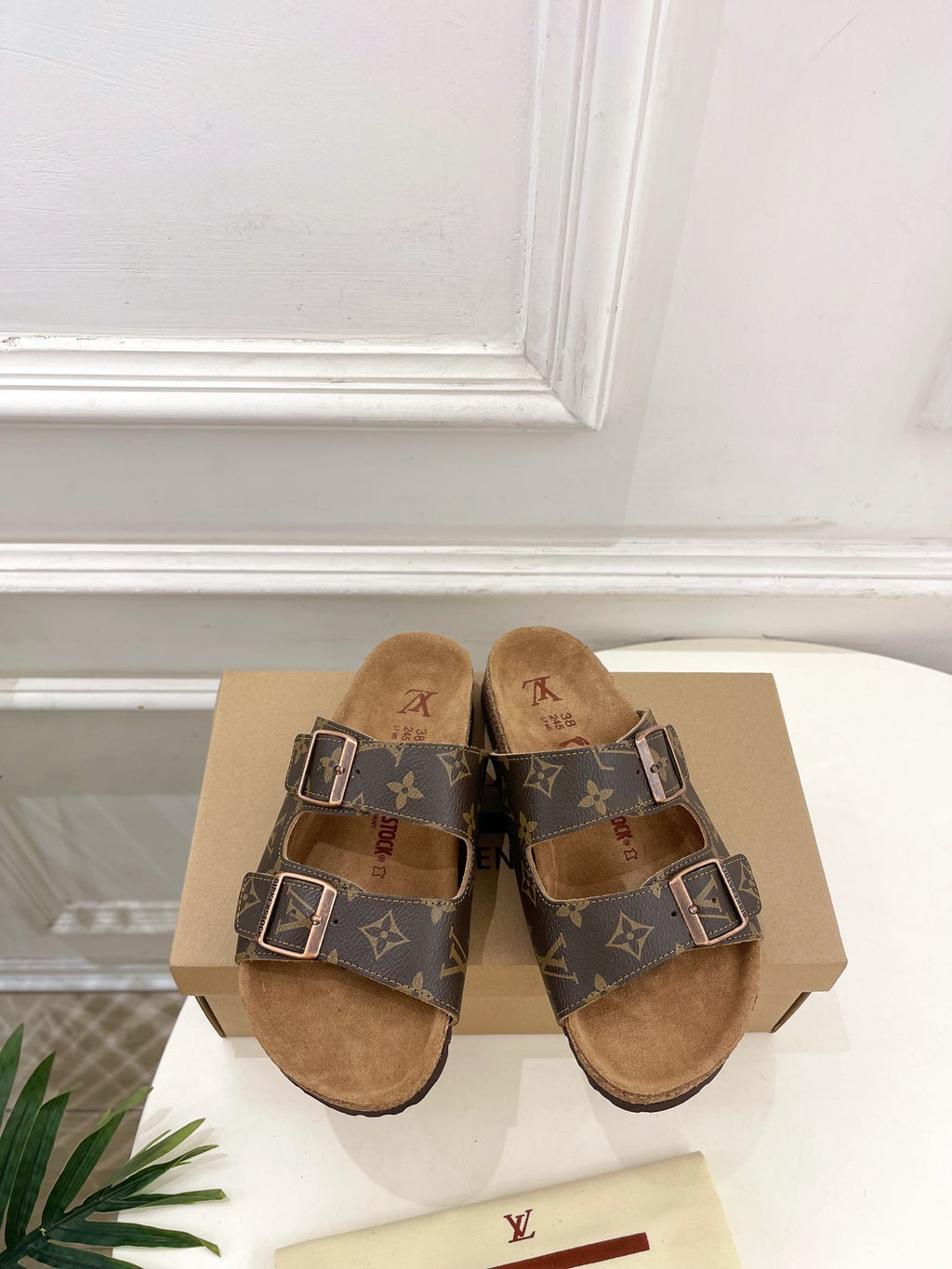 Brown monogram sandals with two adjustable buckled straps and tan suede footbed