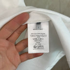 White T-shirt with inner size and care label; 100% cotton content shown.