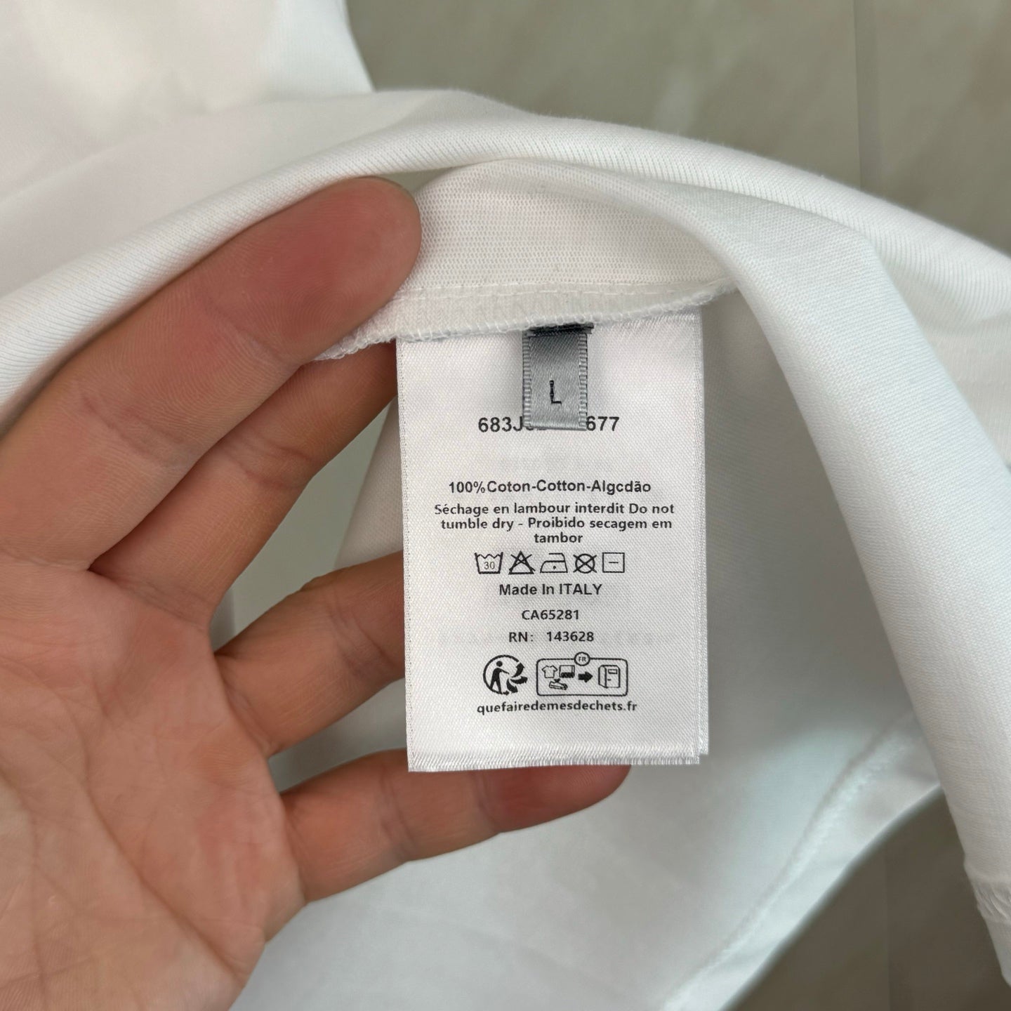 White T-shirt with inner size and care label; 100% cotton content shown.