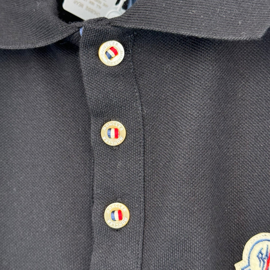 Moncler polo shirt button placket with circular logo buttons, dark navy