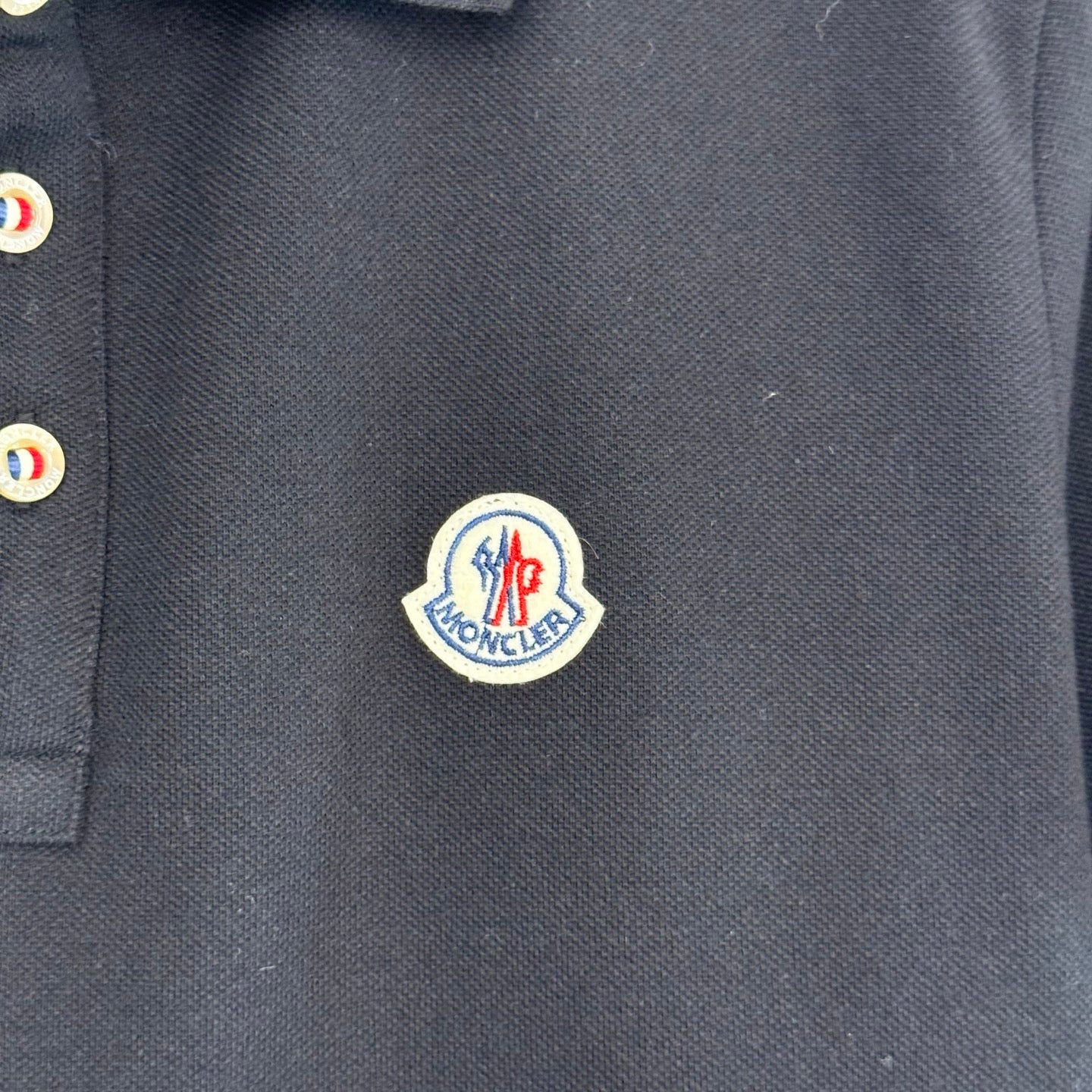 Moncler logo patch on dark navy polo shirt placket area