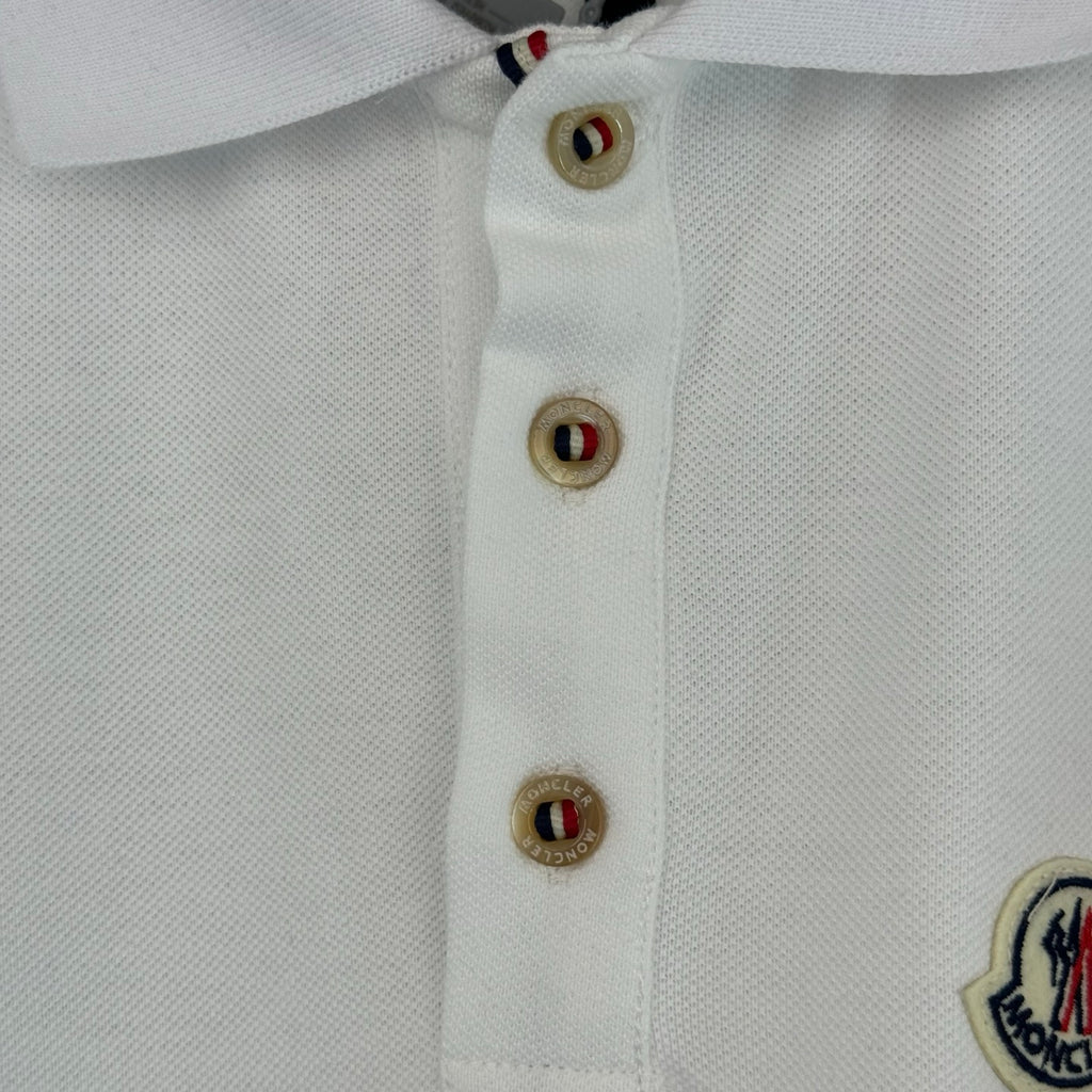 White polo shirt placket with three logo buttons