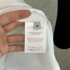 Light garment size label on white fabric, inner tag on shorts