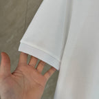 White polo shirt sleeve cuff with textured knit and stitched hem