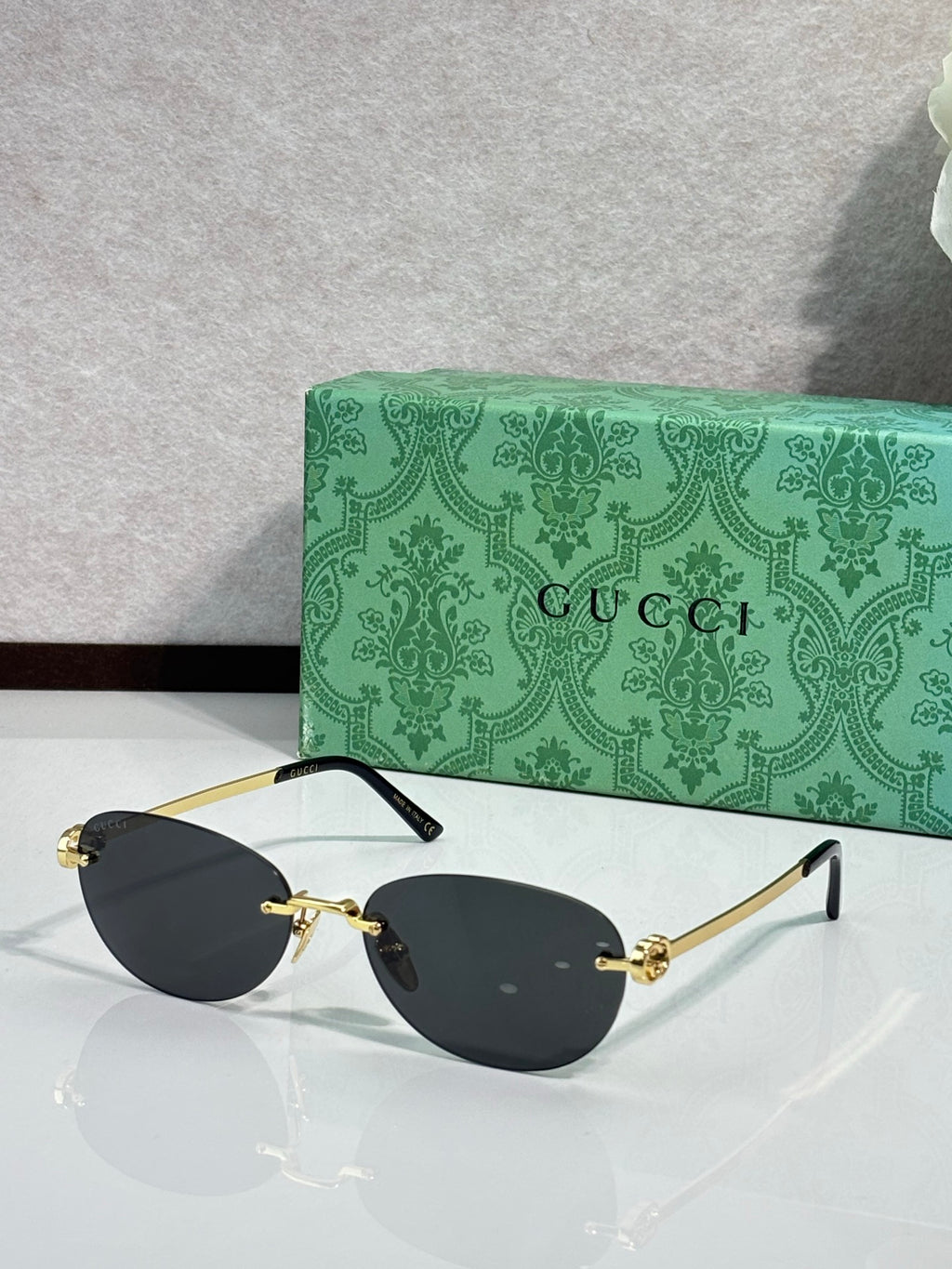 Gucci cat-eye sunglasses with black lenses and gold-tone metal details