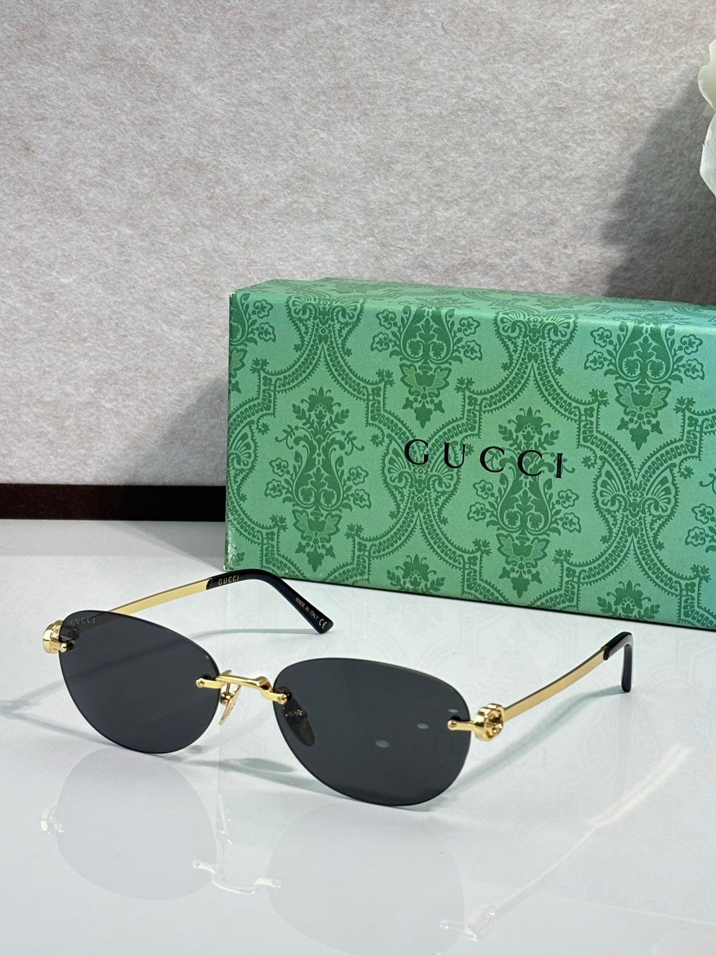 Gucci cat-eye sunglasses with black lenses and gold-tone metal details