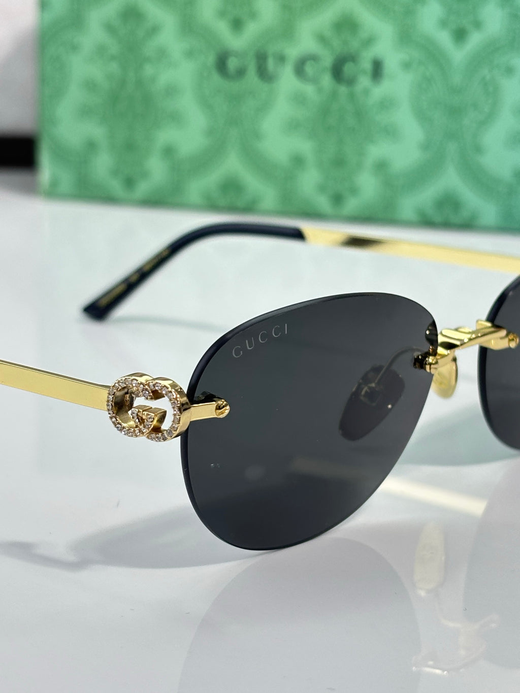 Gucci cat-eye sunglasses close-up with black lenses and gold-tone logo hardware