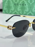 Gucci cat-eye sunglasses close-up with black lenses and gold-tone logo hardware