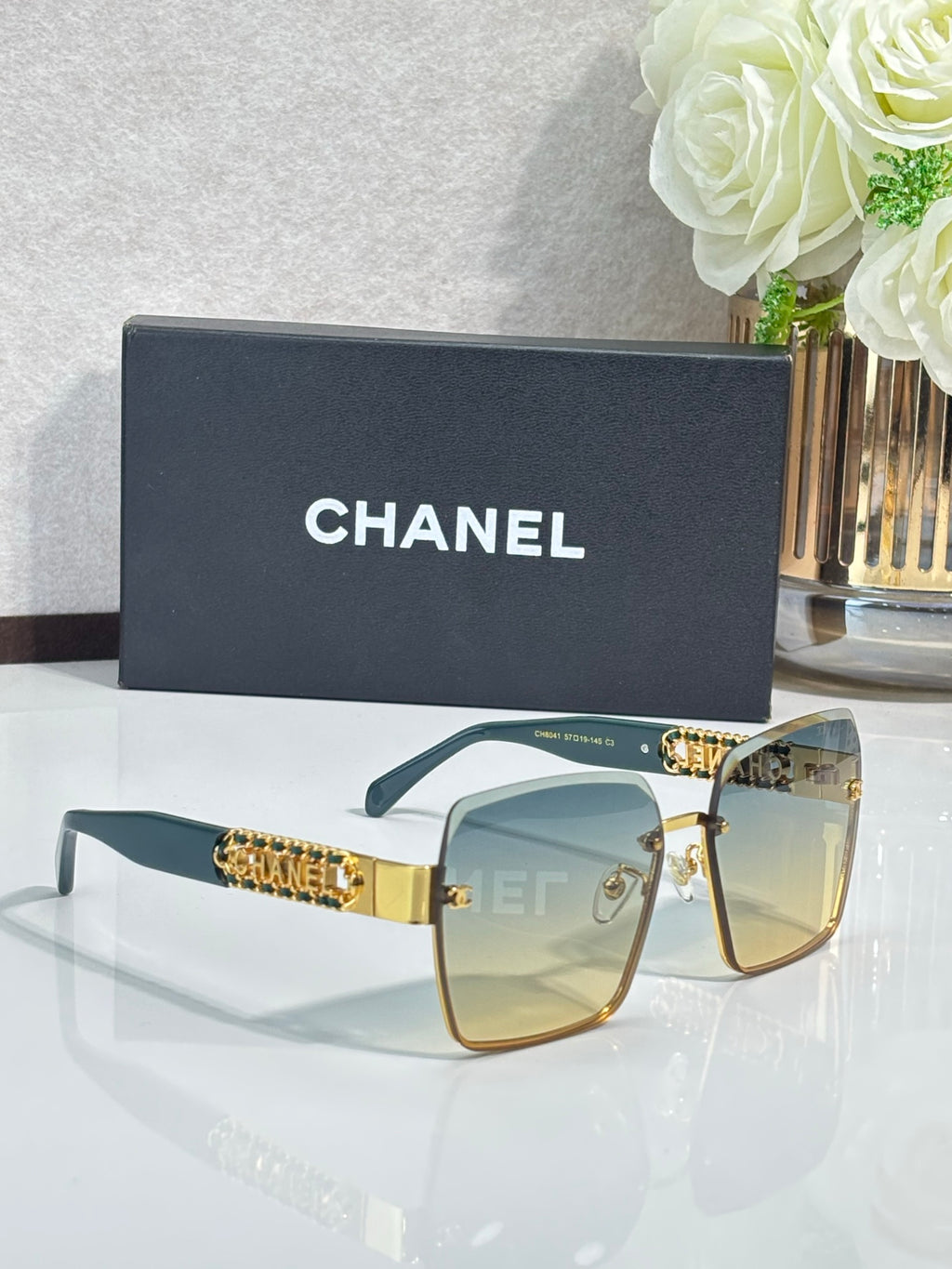 Gold-rim square sunglasses with teal gradient lenses, CHANEL branding on case