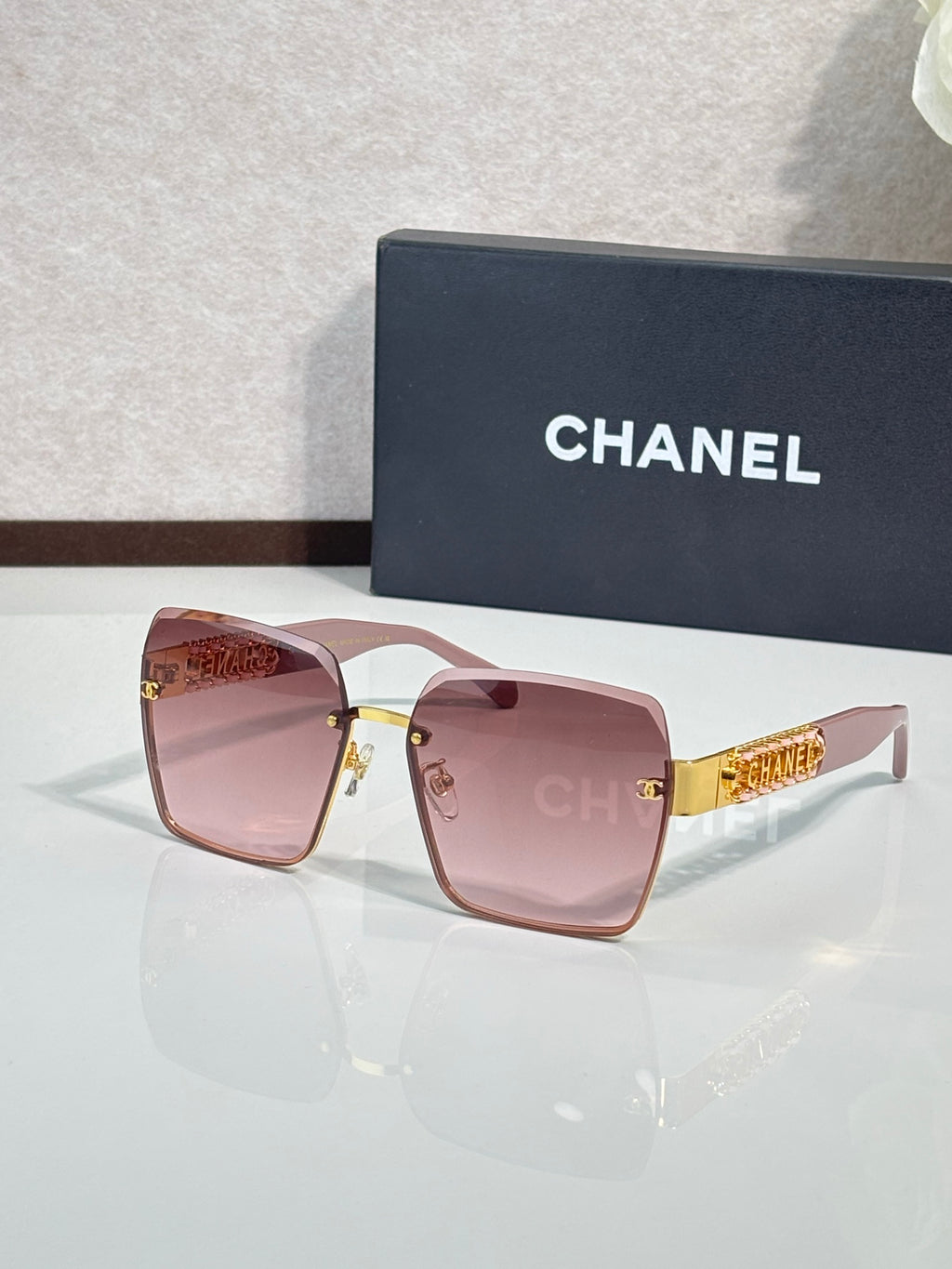 Gold-rim square sunglasses with rose-pink gradient lenses, CHANEL branding on case