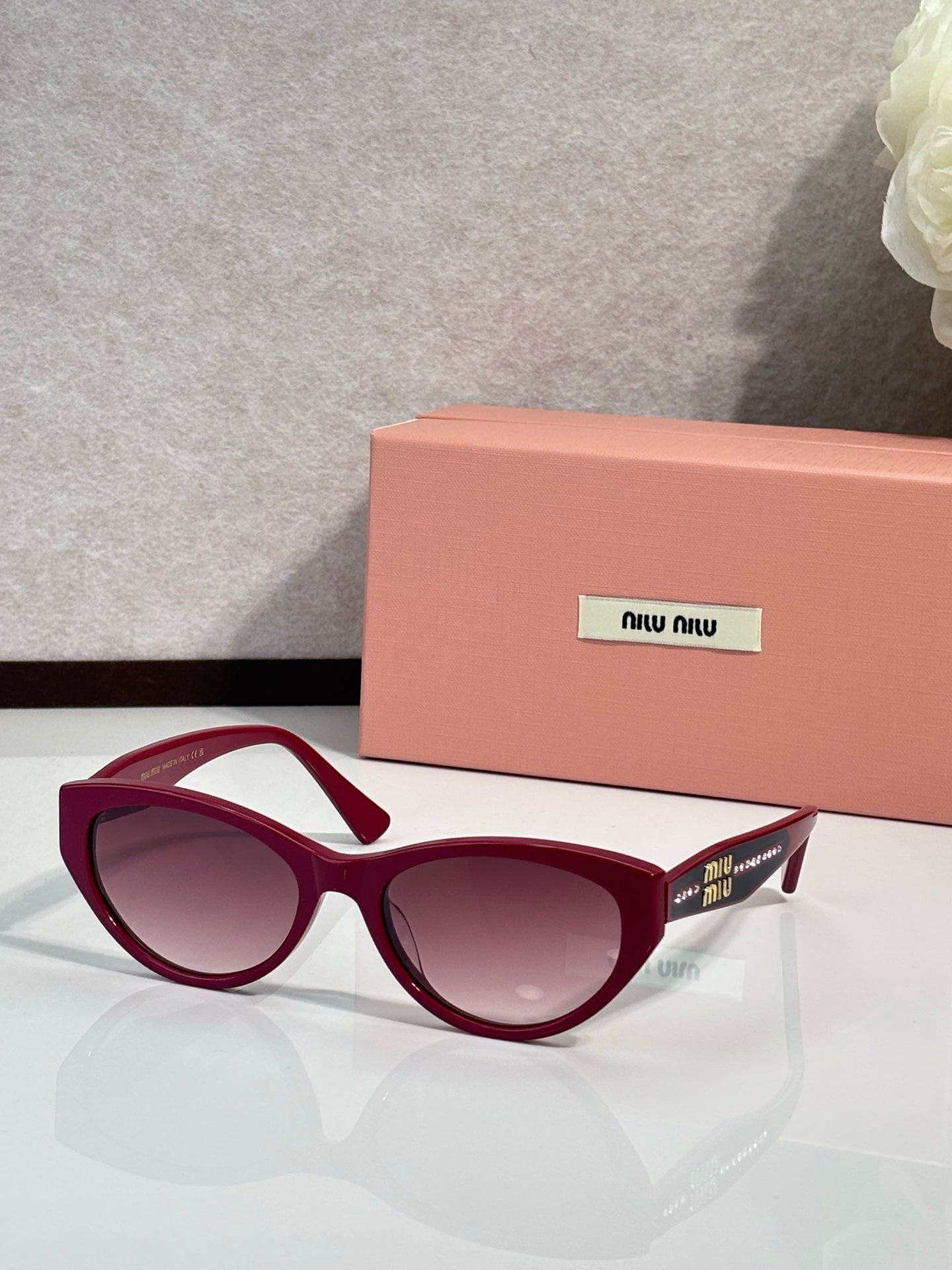 MiuMiu sunglasses with burgundy frames and purple tinted lenses