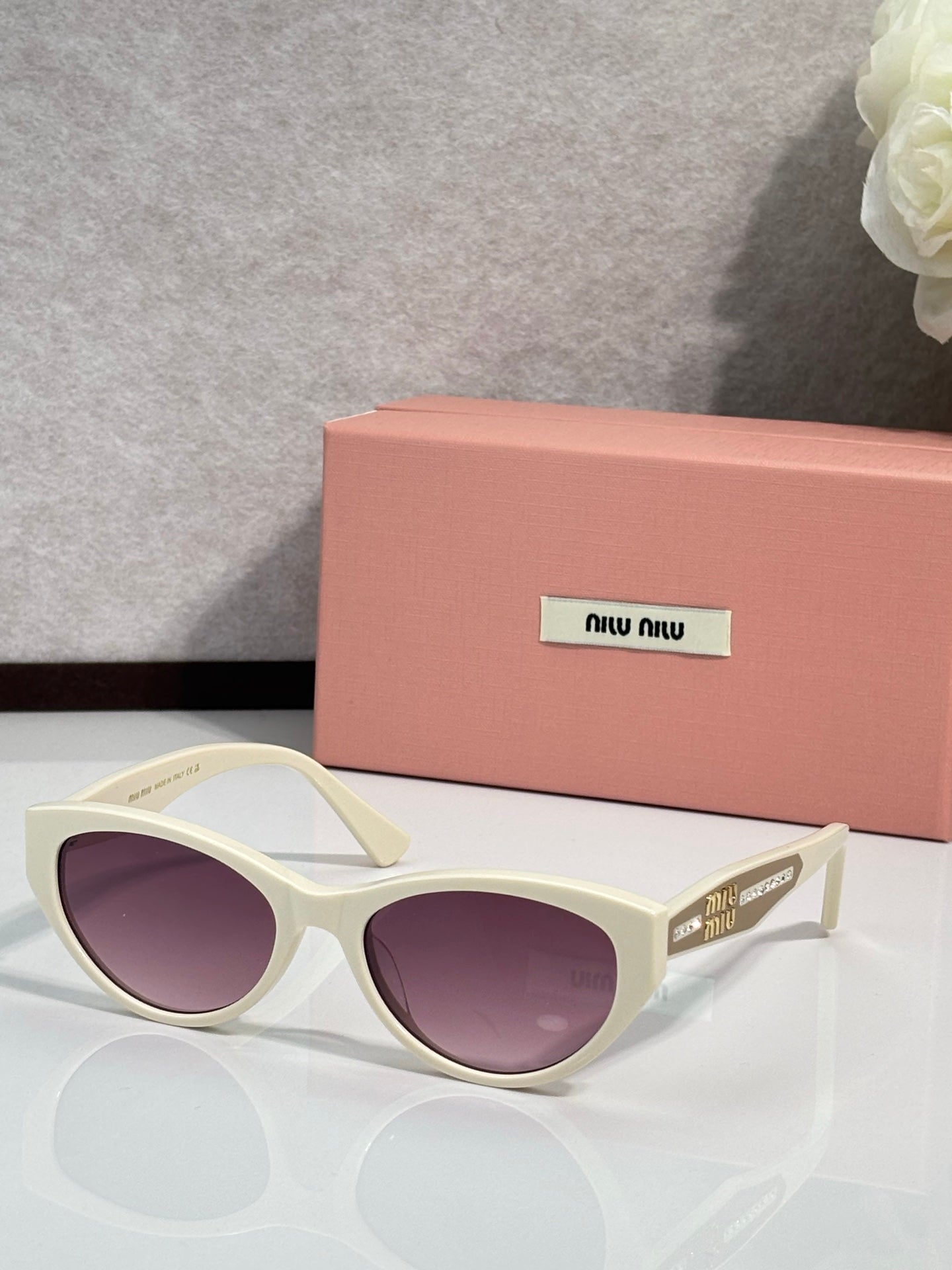MiuMiu sunglasses with cream frames and purple tinted lenses