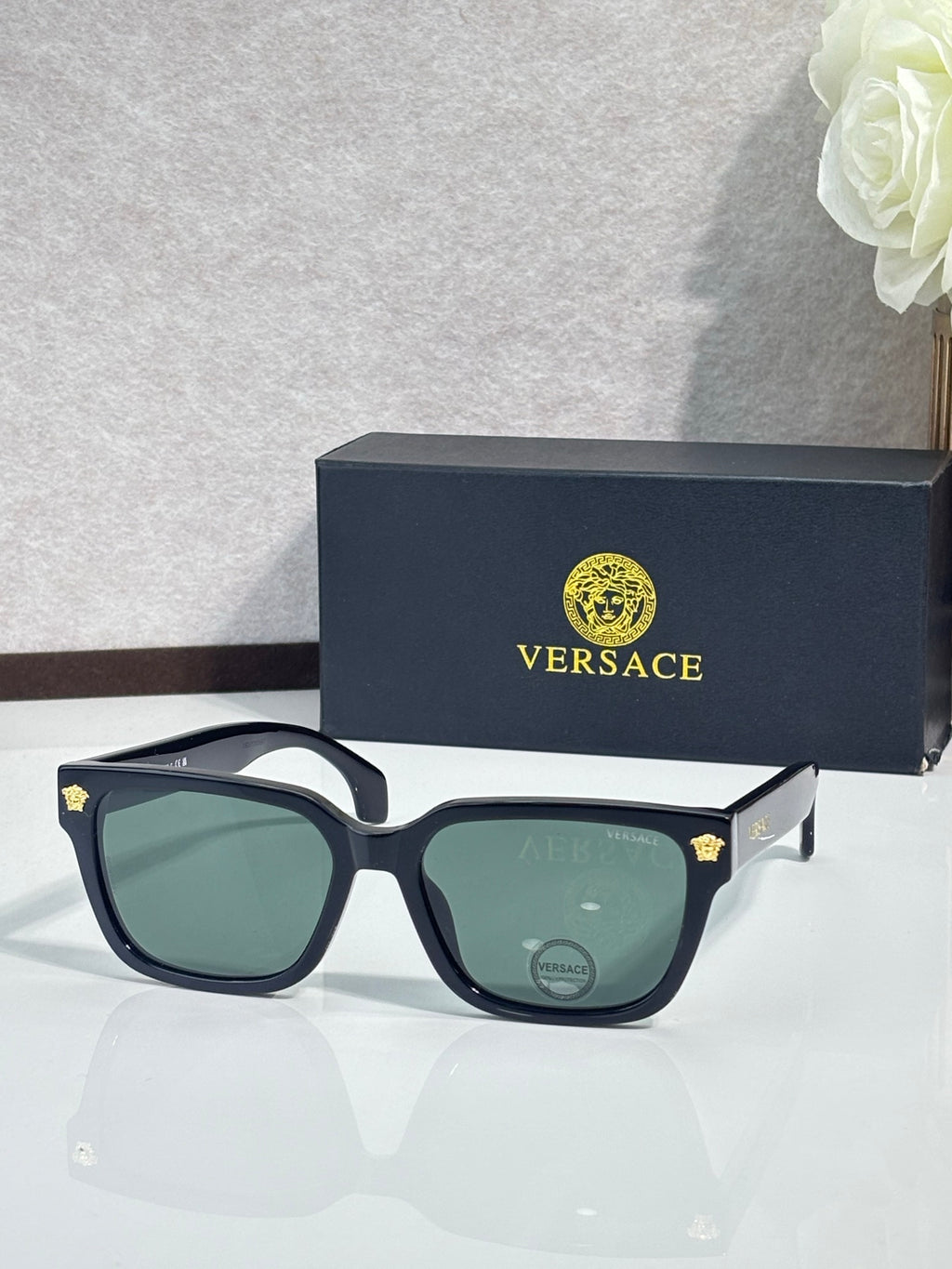 Versace sunglasses with dark blue frames and green tinted lenses