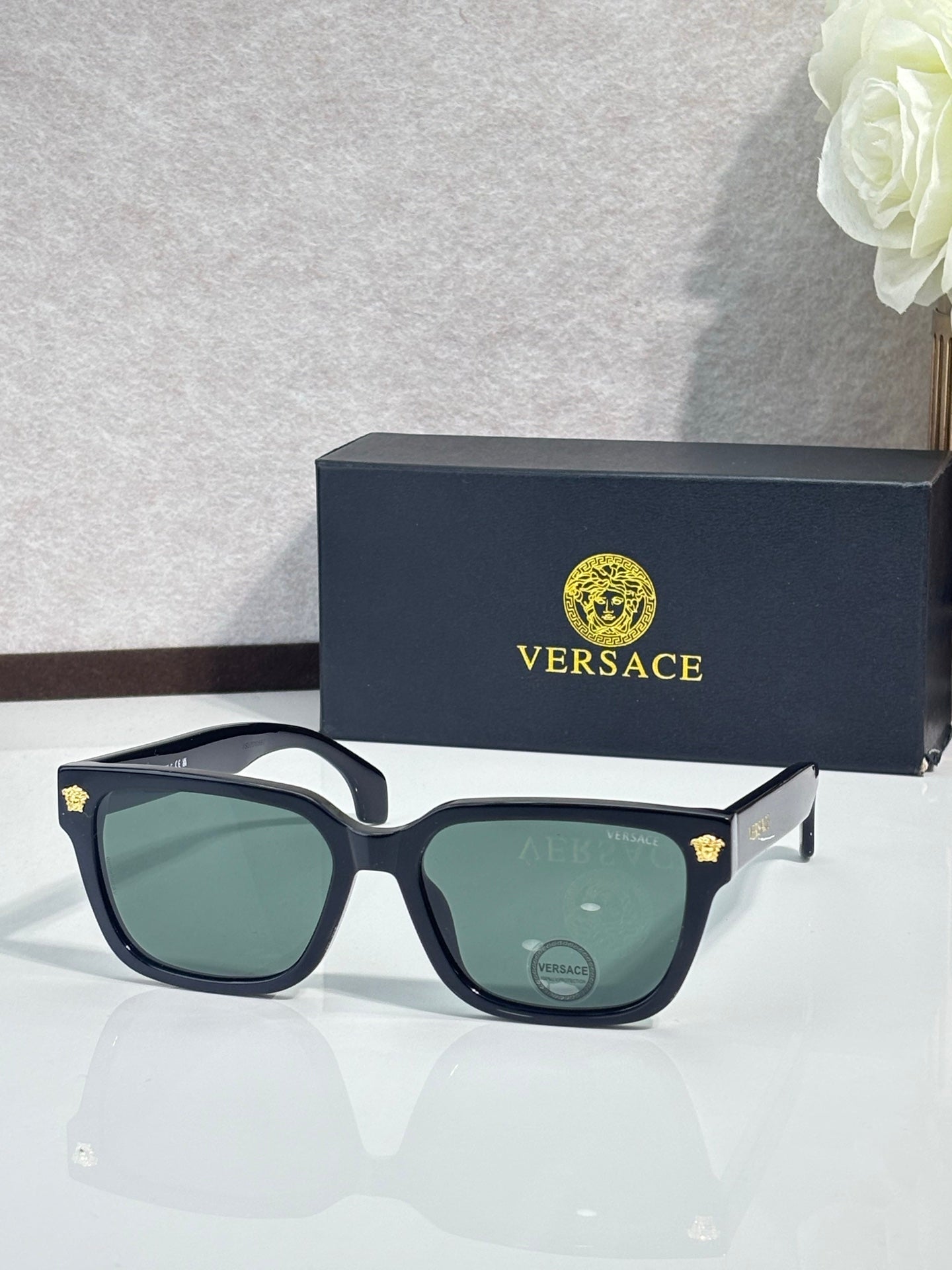 Versace sunglasses with dark blue frames and green tinted lenses