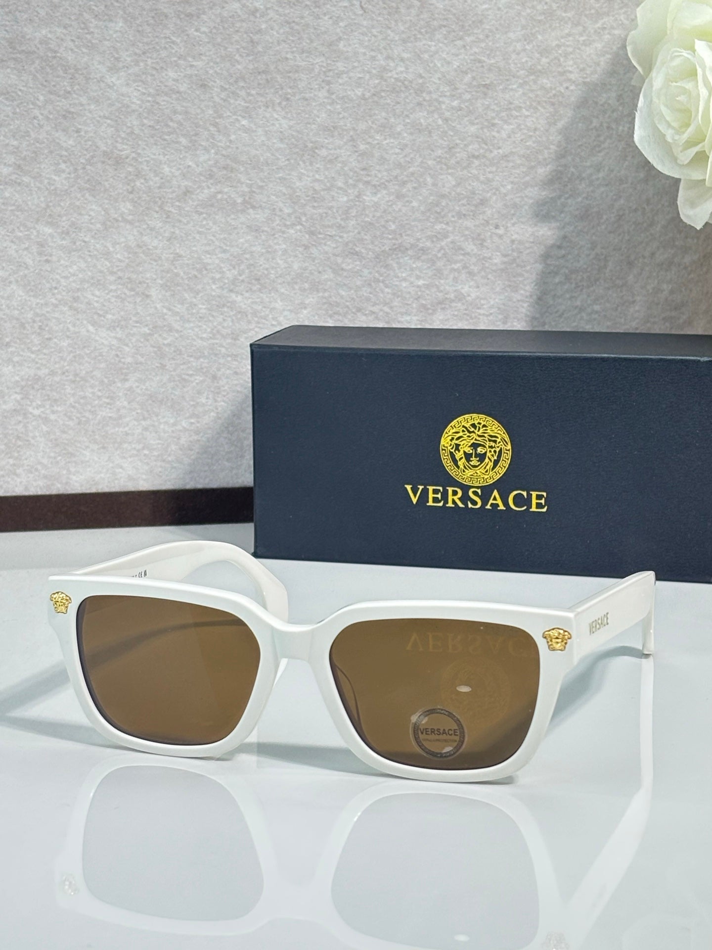 Versace sunglasses with white rectangular frames and brown tinted lenses