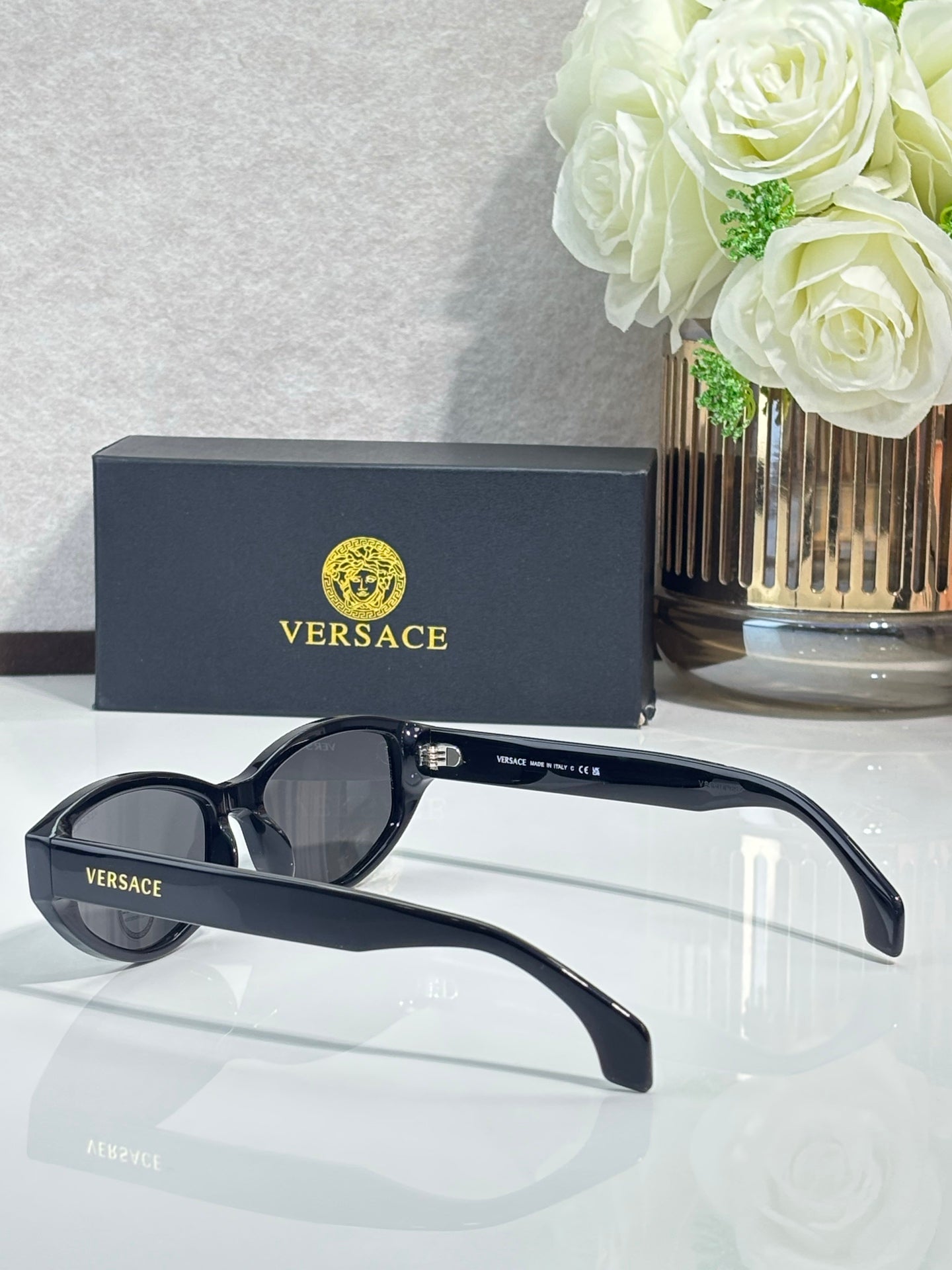 Versace sunglasses with black frame and blue-gray lenses, open side view