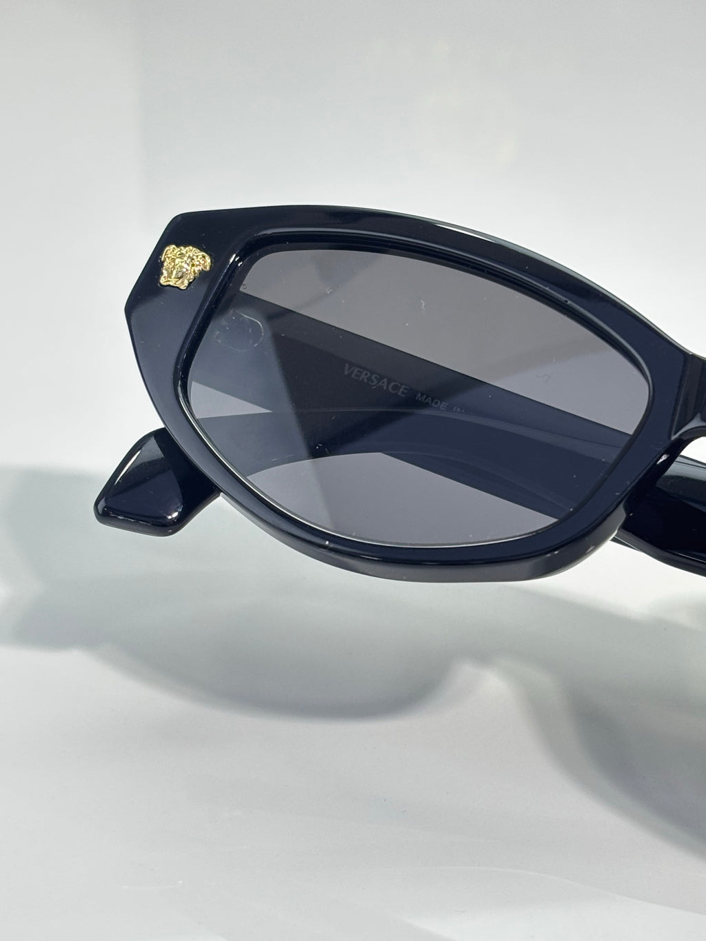 Versace sunglasses side profile with dark blue frame and blue-gray lenses