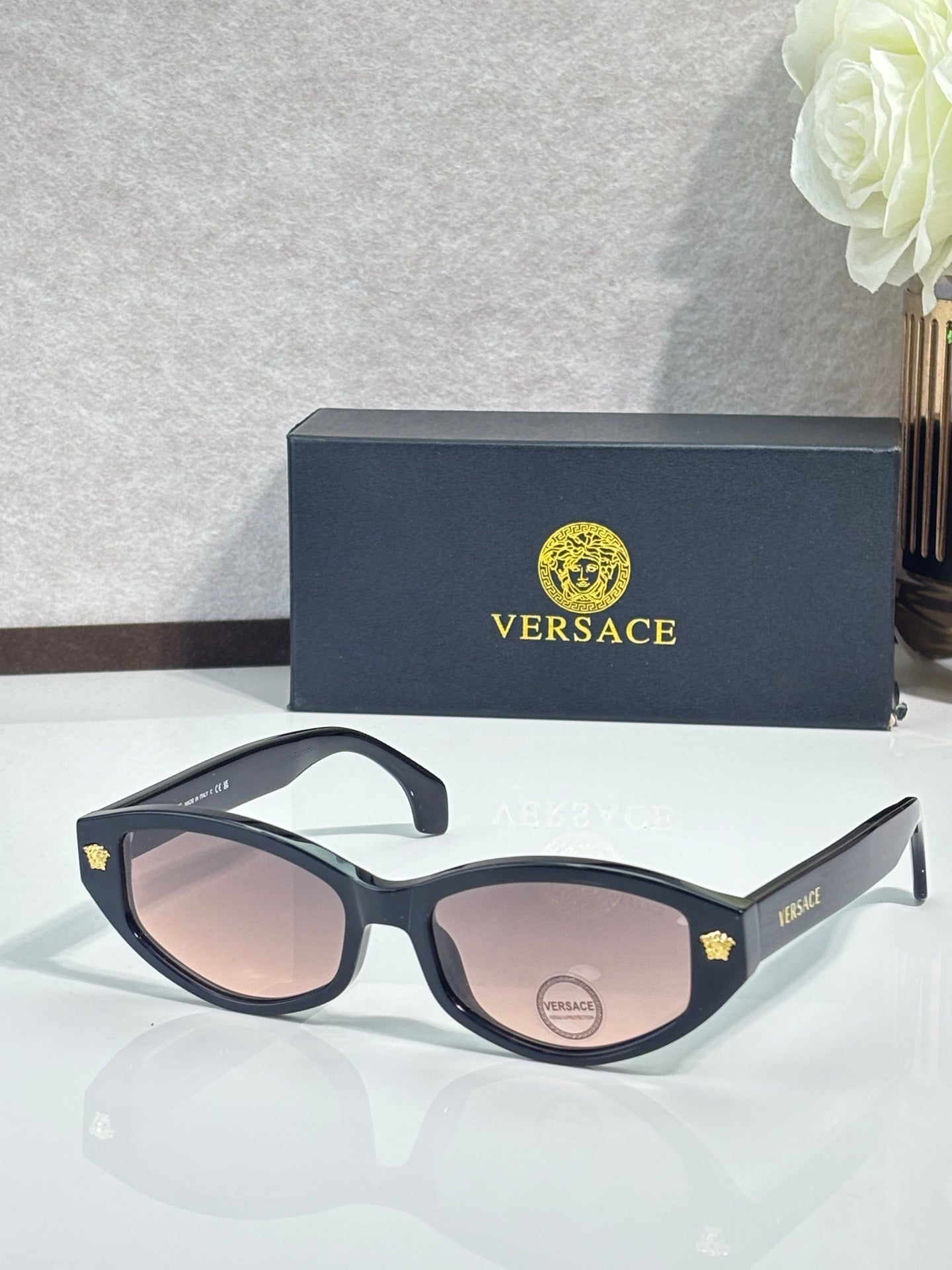Versace sunglasses with black frame and pink tinted lenses