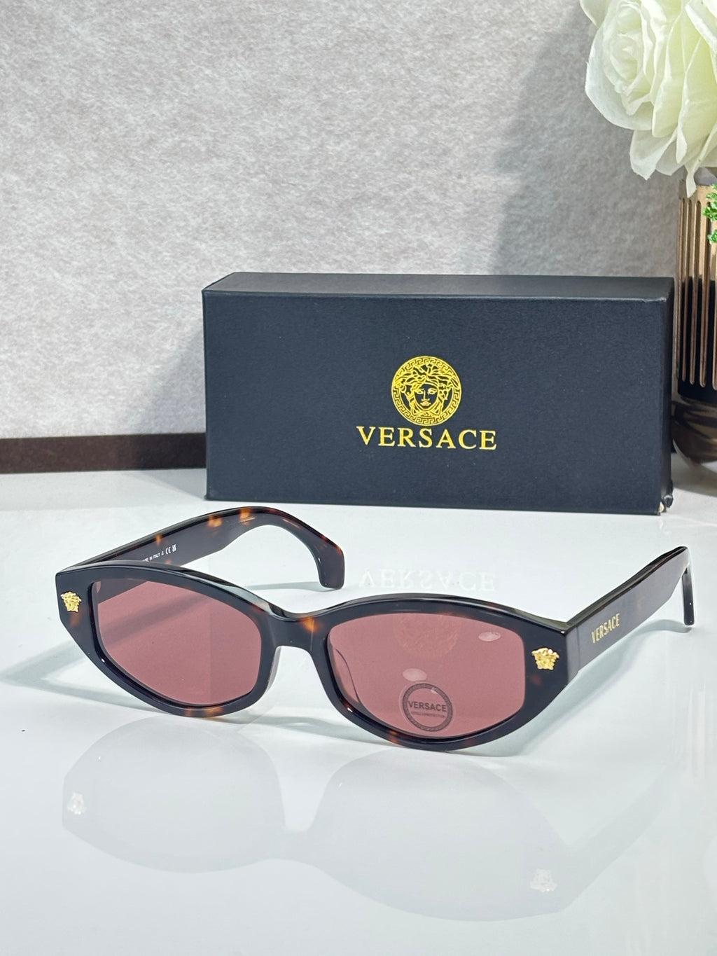 Versace sunglasses with dark tortoiseshell frame and pink tinted lenses