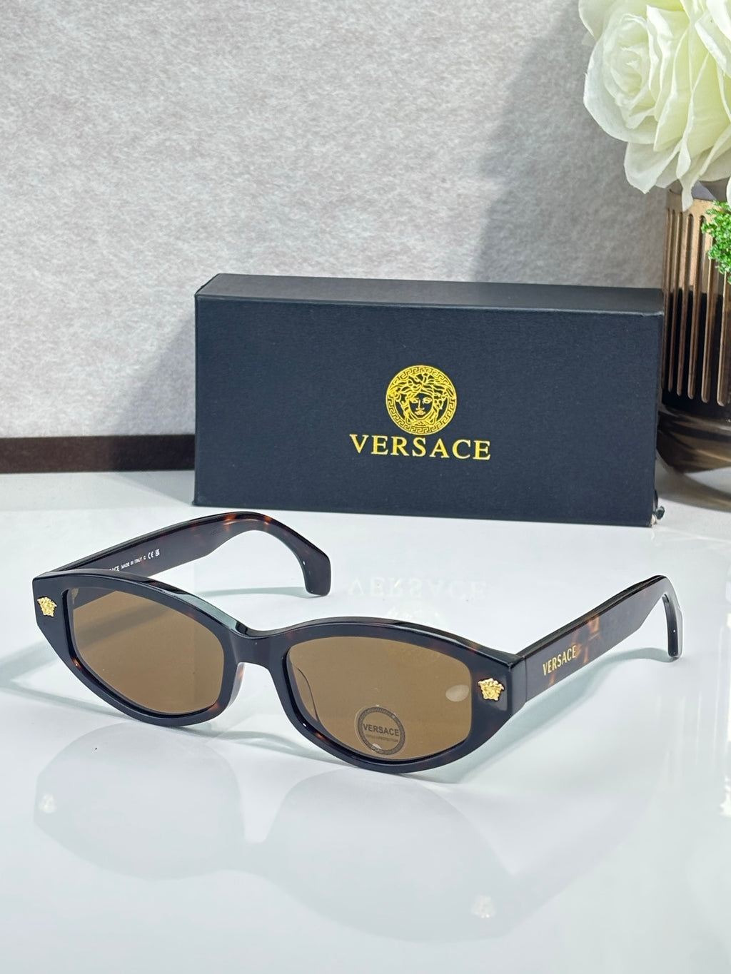 Versace sunglasses with dark frame and brown lenses, gold logo accents